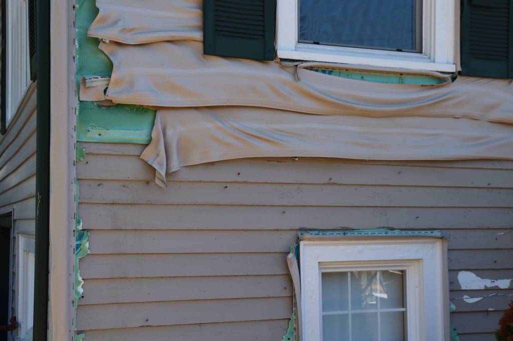 Radiant heat from a hedge fire on Glenwood Avenue melted the homes siding down to the original cedar on July 17, 2026, in Everett, Washington. (Ian Davis-Leonard/The Daily Herald)