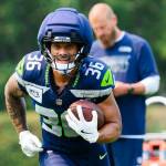 Seahawks running back George Holani (36) runs with the ball as offensive coordinator Brian Fleury looks at his call sheet at training camp on Thursday at the Virginia Mason Athletic Center in Renton. (Photo courtesy of Edwin Hooper / Seattle Seahawks)