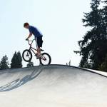 Perry Elliott pops a wheelie at the top of the new skate dot at Lions Park on Thursday, Aug. 6, 2026 in Everett, Washington. (Olivia Vanni / The Herald)