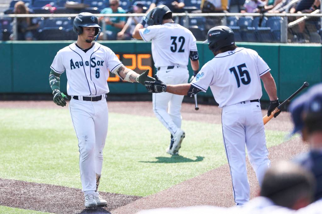 Korbyn Dickerson #5 of the Everett AquaSox high fives Aiden Taurek #15 of the Everett AquaSox after his two-run homer during the game against the Spokane Indians on Thursday, Aug. 13, 2026 in Everett, Washington. (Olivia Vanni / The Herald)